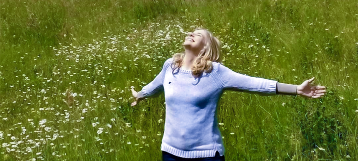 Woman rejoicing in a green meadow at the birth of a son
