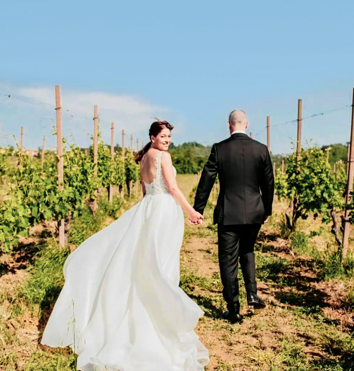 The newlyweds Ela and Fabio walk hand in hand at Villa Spina