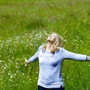 Woman rejoicing in a green meadow at the birth of a son